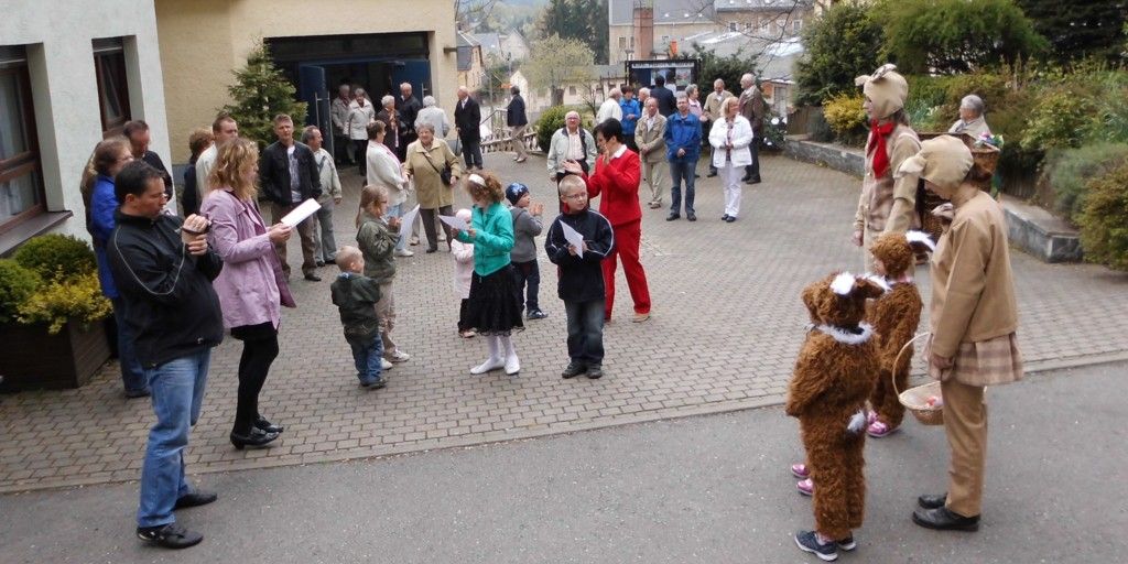 Messbesucher und Osterhasen auf dem Kirchenvorplatz
